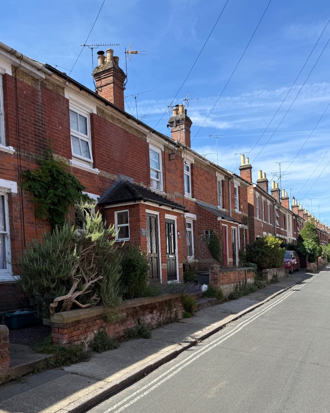 Red-brick Victorian terrace in Essex, showing sash windows and roofline along the street